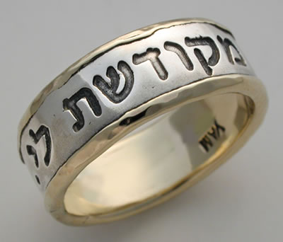 A traditional gold wedding band engraved with Hebrew writing